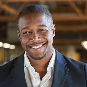 a smiling man in a casual business suit