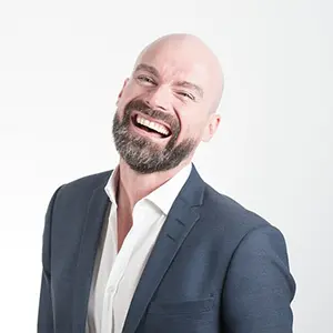 a smiling man in a casual business suit